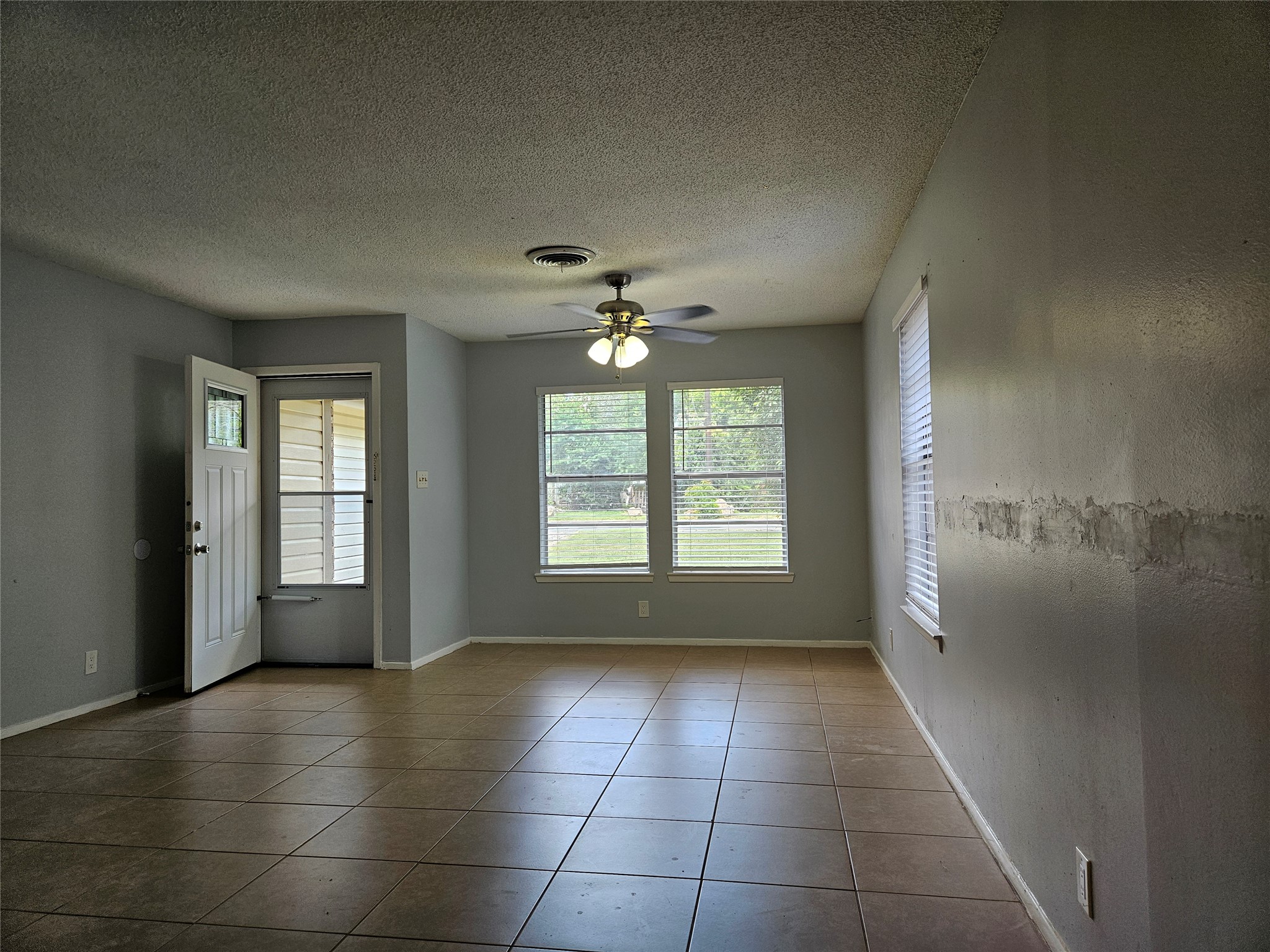 806 Ranch Road, Unit A Georgetown, TX 78628 - Photo 4 of 24 A versatile living area features tiled flooring, abundant natural light, and a cooling ceiling fan.