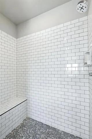 a bathroom with a sink shower and a mirror