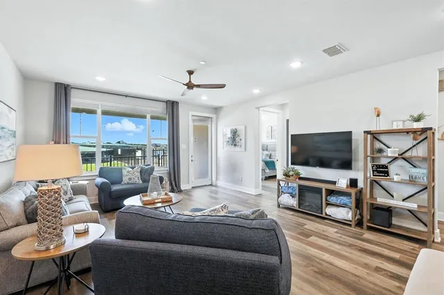 a living room with furniture and a view of kitchen