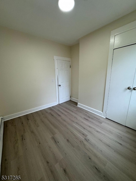 10 Riverside Place Garfield, NJ 07026 - Photo 12 of 26 an empty room with wooden floor and windows