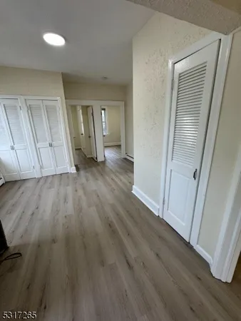 an empty room with wooden floor and closet
