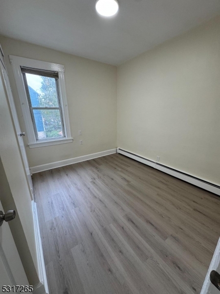 10 Riverside Place Garfield, NJ 07026 - Photo 5 of 26 an empty room with wooden floor and windows