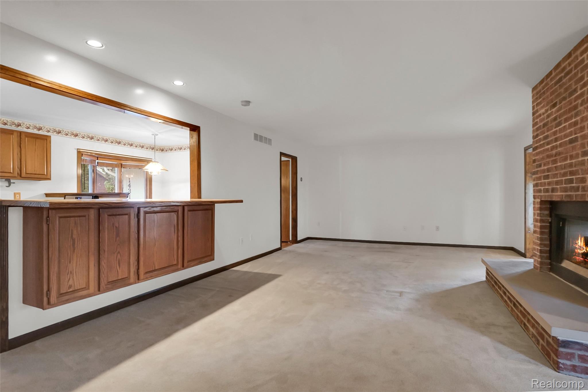 1431 East Commerce Road Commerce Township, MI 48382 - Photo 13 of 27 Unfurnished living room with a fireplace, light colored carpet, and recessed lighting