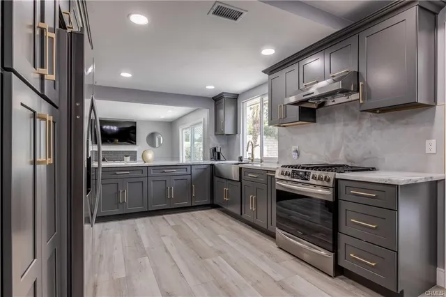 a kitchen with stainless steel appliances granite countertop a stove a sink and a refrigerator