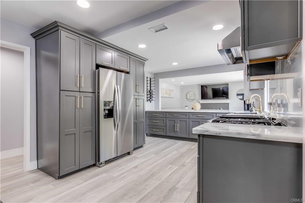 10664 Morning Glory Avenue Fountain Valley, CA 92708 - Photo 12 of 31 a kitchen with stainless steel appliances granite countertop a refrigerator a sink dishwasher a stove and a refrigerator with wooden floor