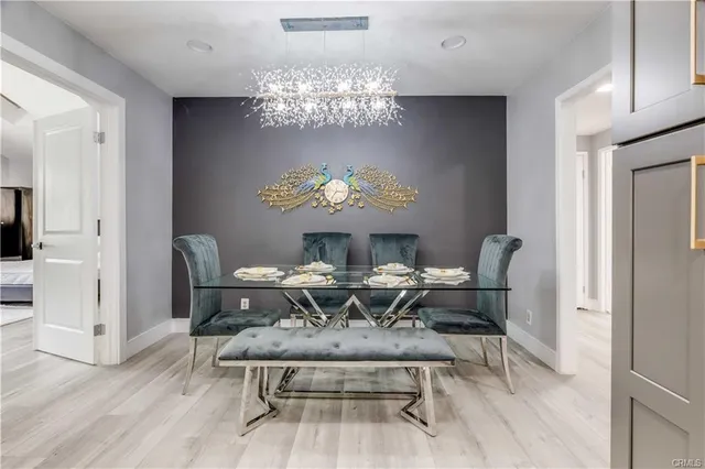 a view of a dining room with furniture a chandelier and wooden floor