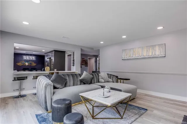 a living room with furniture a flat screen tv and kitchen view