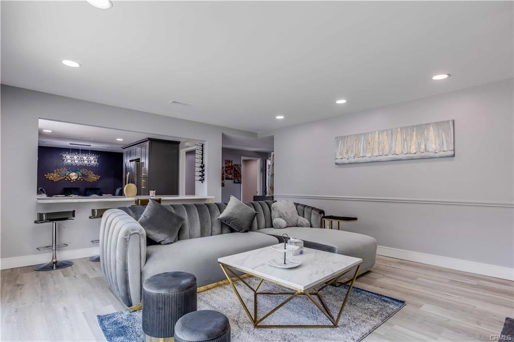 10664 Morning Glory Avenue Fountain Valley, CA 92708 - Photo 5 of 31 a living room with furniture a flat screen tv and kitchen view