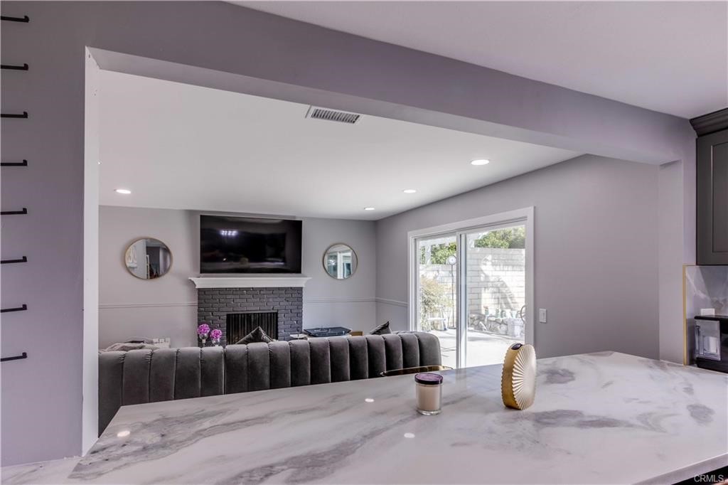 10664 Morning Glory Avenue Fountain Valley, CA 92708 - Photo 6 of 31 a living room with furniture a flat screen tv and a fireplace