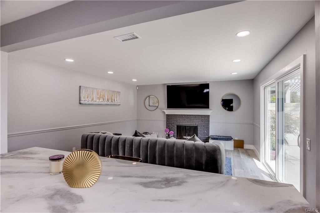 10664 Morning Glory Avenue Fountain Valley, CA 92708 - Photo 7 of 31 a living room with furniture a fireplace and a flat screen tv