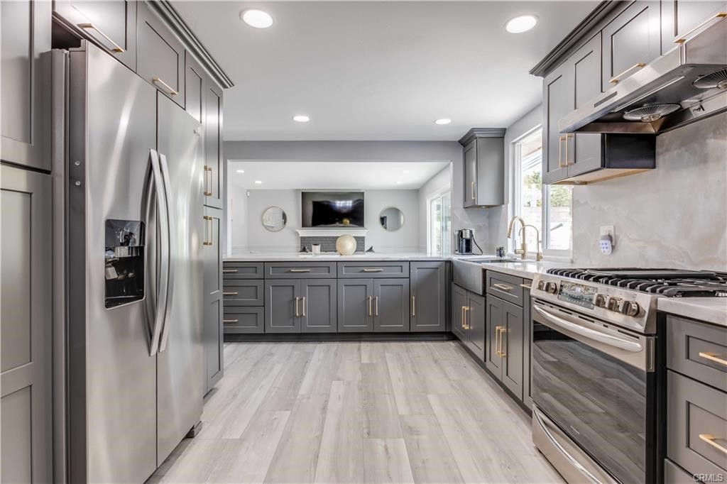 10664 Morning Glory Avenue Fountain Valley, CA 92708 - Photo 10 of 31 a kitchen with stainless steel appliances a refrigerator a sink dishwasher a stove and white cabinets