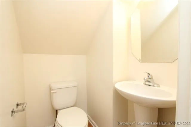 a bathroom with a toilet a sink and a mirror