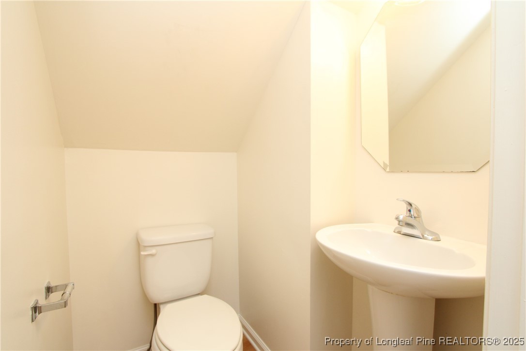 6124 Deerwood Place Raleigh, NC 27607 - Photo 6 of 22 a bathroom with a toilet a sink and a mirror