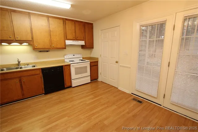 a kitchen with stainless steel appliances granite countertop a sink stove and cabinets