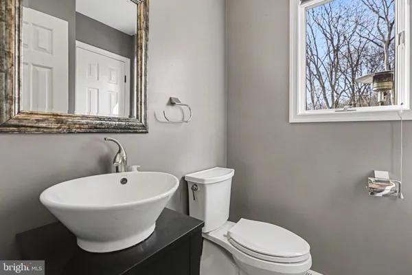a bathroom with a toilet a sink and mirror