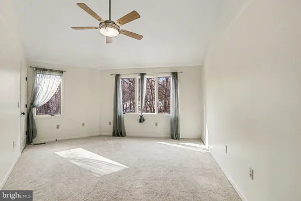 an empty room with fan and windows