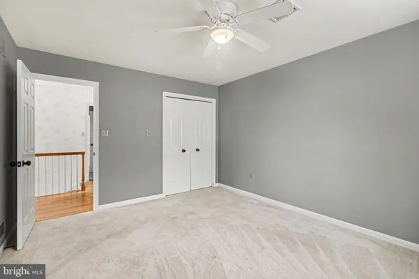 a view of an empty room and chandelier fan