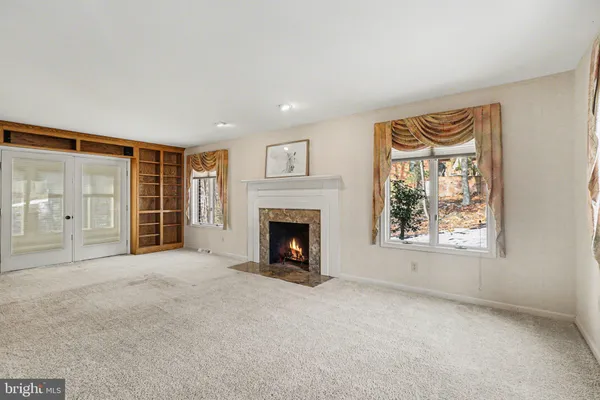 a view of an empty room with a fireplace and a window