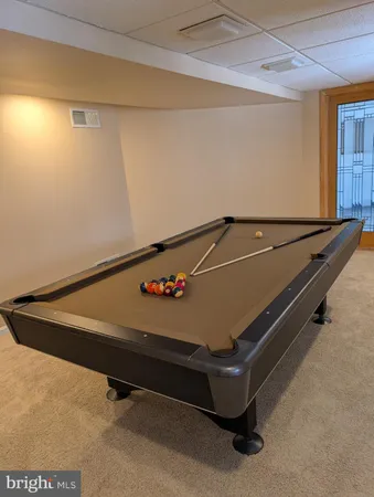 a room with pool table and windows