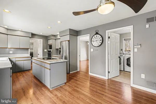 a kitchen with stainless steel appliances granite countertop a refrigerator a stove and a wooden floors