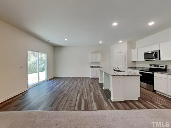 a open kitchen with kitchen island white cabinets and stainless steel appliances