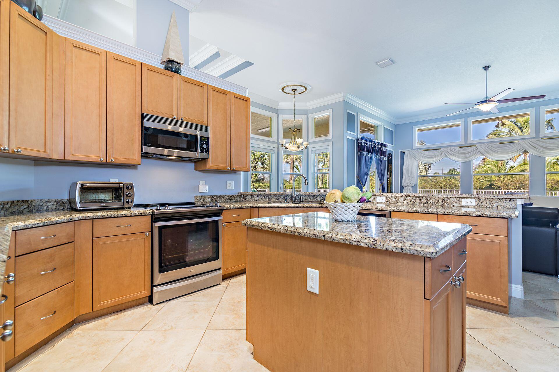 6813 Wilson Road West Palm Beach, FL 33413 - Photo 13 of 26 a kitchen with stainless steel appliances granite countertop a sink a stove and a microwave