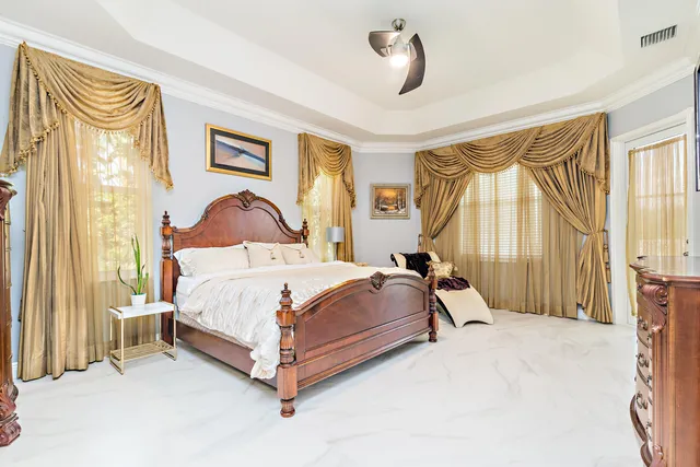 a bedroom with a bed lamp and a large window