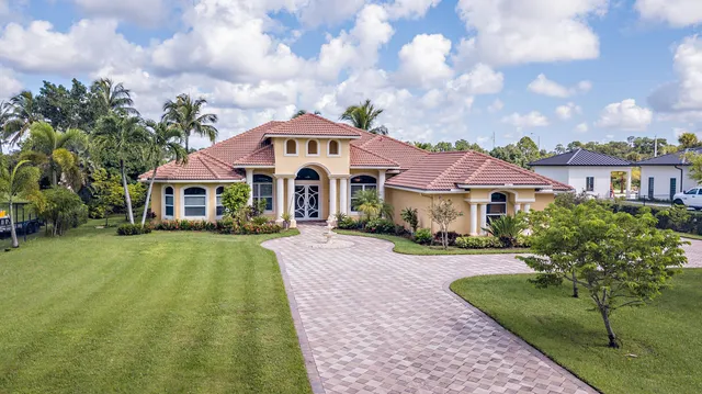 a front view of a house with yard and green space