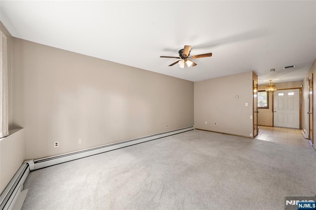 140 Allwood Road, Unit C Clifton, NJ 07012 - Photo 6 of 31 an empty room with chandelier fan and windows