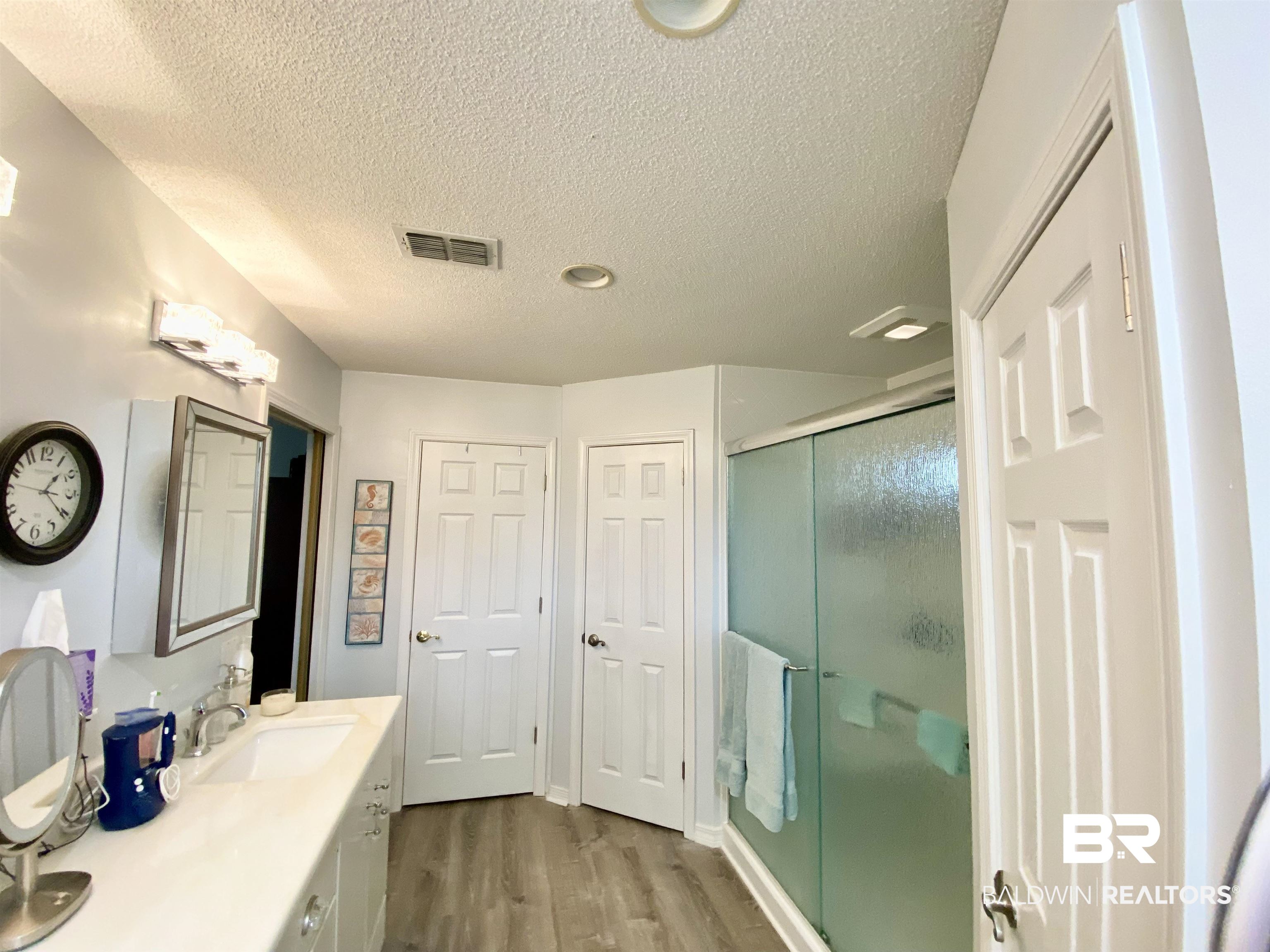 2872 Avenida Alberto Lillian, AL 36549 - Photo 18 of 31 Bathroom with hardwood / wood-style floors, vanity, an enclosed shower, and a textured ceiling