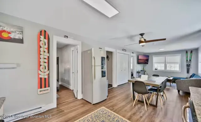 a kitchen with stainless steel appliances granite countertop a refrigerator a stove top oven a chimney and a dining table view