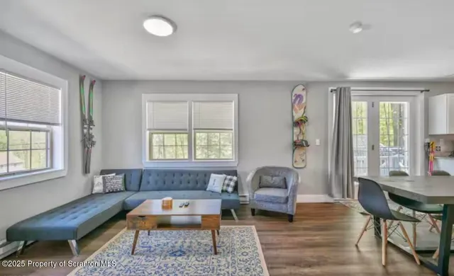 a living room with furniture a flat screen tv and a window