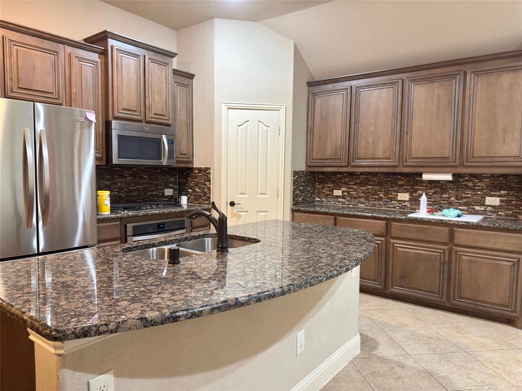 1017 Knoxbridge Road Forney, TX 75126 - Photo 11 of 16 a kitchen with stainless steel appliances granite countertop a refrigerator a stove a sink and white cabinets