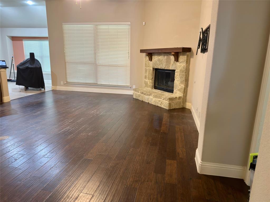 1017 Knoxbridge Road Forney, TX 75126 - Photo 5 of 16 an empty room with wooden floor fireplace and windows