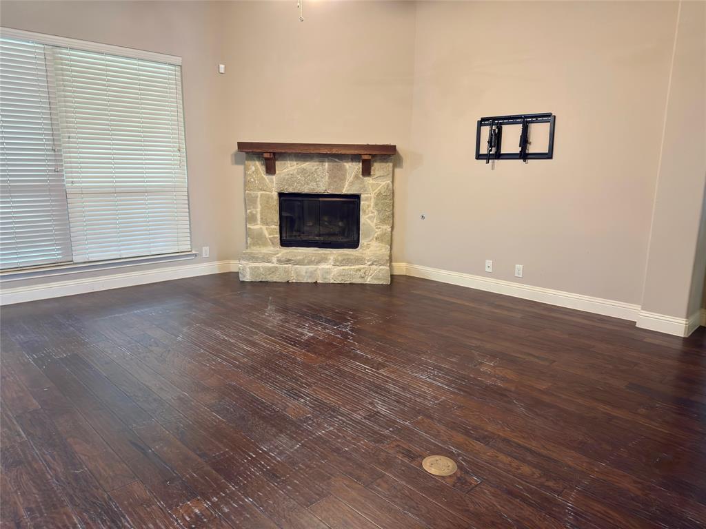 1017 Knoxbridge Road Forney, TX 75126 - Photo 6 of 16 an empty room with wooden floor fireplace and windows