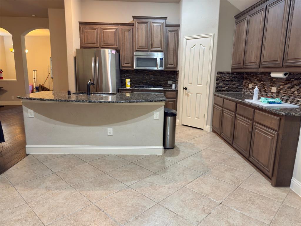 1017 Knoxbridge Road Forney, TX 75126 - Photo 9 of 16 a kitchen with stainless steel appliances granite countertop a stove a sink and a refrigerator
