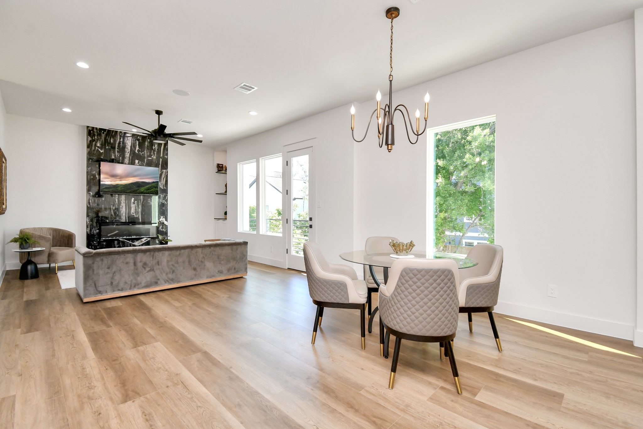 2512 Gray Street Houston, TX 77003 - Photo 46 of 46 This modern living space features an open floor plan with sleek wood flooring, a cozy seating area with a TV wall, and a stylish dining nook with a chic chandelier. Large windows and a glass door provide ample natural light.