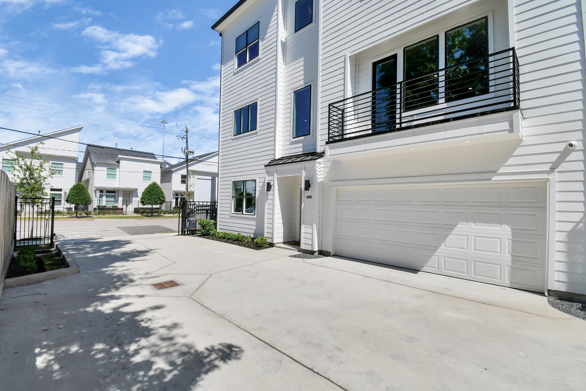2512 Gray Street Houston, TX 77003 - Photo 2 of 46 This modern home features a sleek white exterior with large windows and a double garage. The driveway is spacious, and the neighborhood has a clean, contemporary feel.