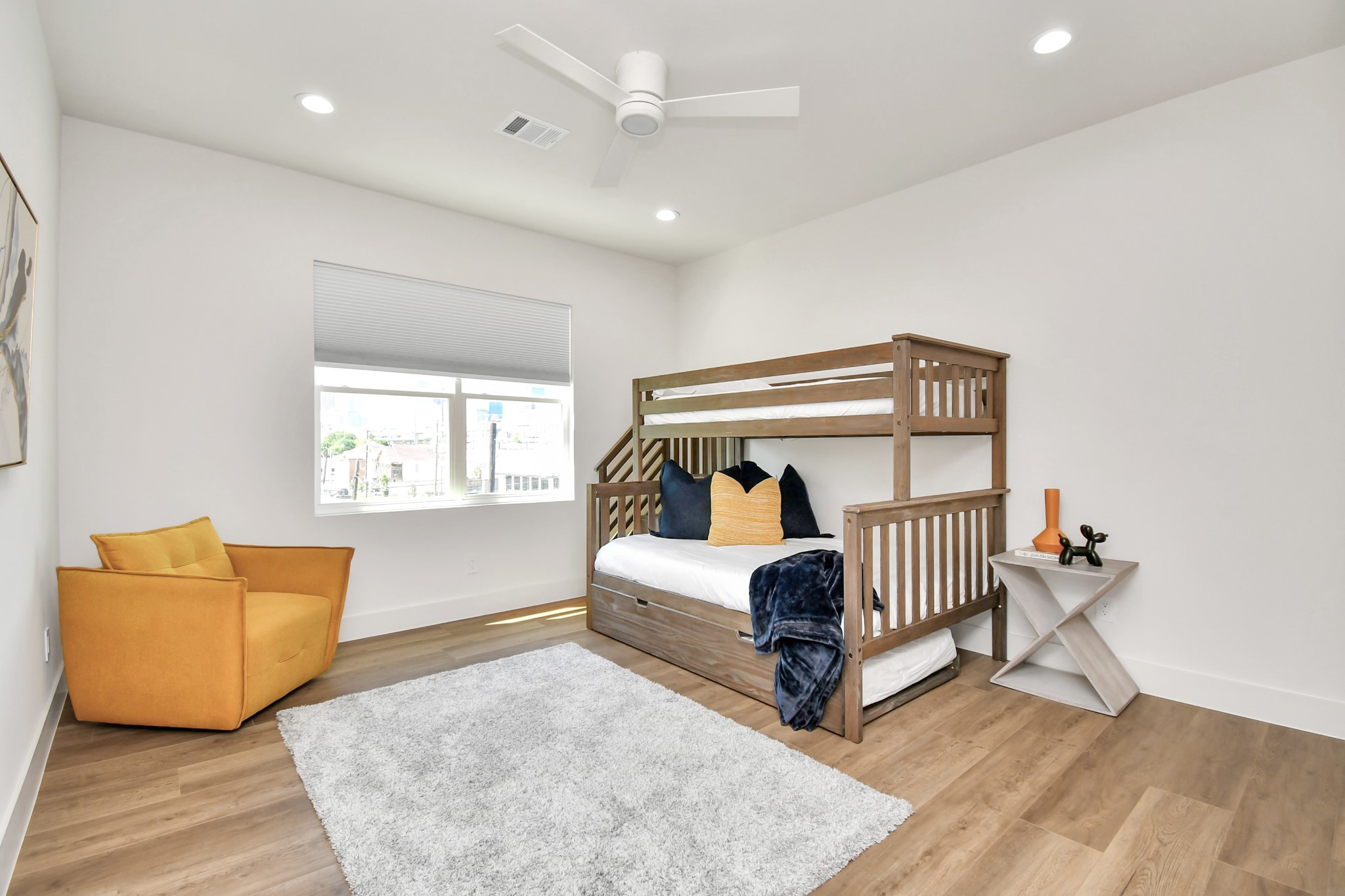 2512 Gray Street Houston, TX 77003 - Photo 35 of 46 This bright bedroom features a cozy bunk bed, a plush area rug, and a stylish armchair. The room is complemented by a modern ceiling fan and ample natural light from a large window.