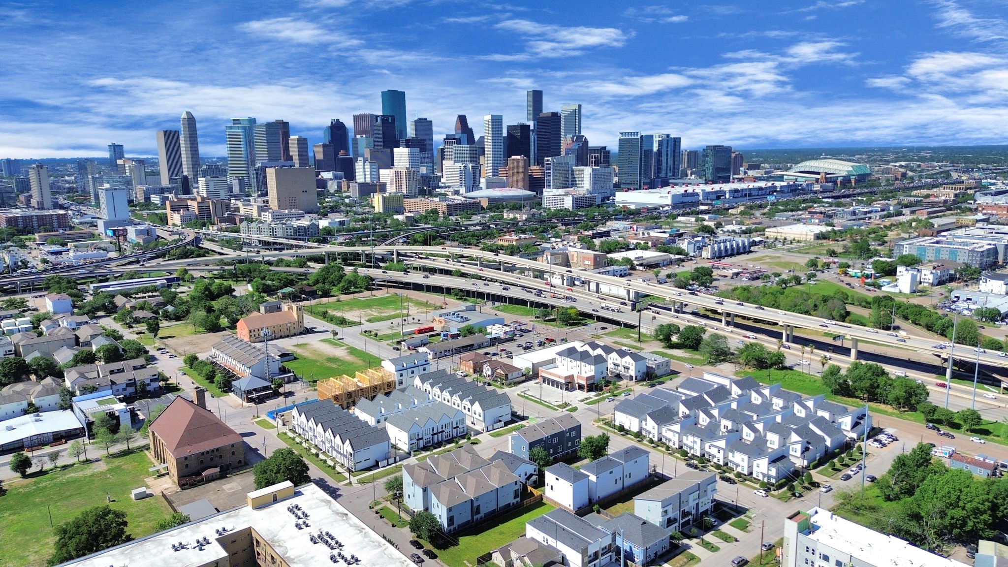 2512 Gray Street Houston, TX 77003 - Photo 44 of 46 This aerial photo showcases a vibrant urban neighborhood with a mix of modern homes and green spaces, set against a backdrop of a bustling city skyline. The area features convenient access to major highways and is ideal for those looking to be near downtown amenities while enjoying a residential feel.