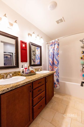 913 South McCall Street Ridgecrest, CA 93555 - Photo 22 of 40 a spacious bathroom with a bathtub double sink and a mirror