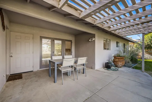 a dining room with furniture and a floor to ceiling window