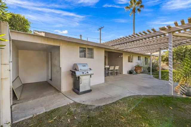 a view of a patio with a table and chairs under an umbrella