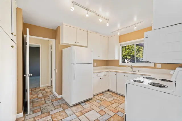 a kitchen with cabinets appliances and a window