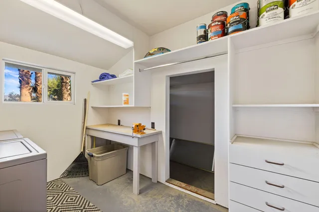 a view of a hallway to room with wooden floor and cabinet