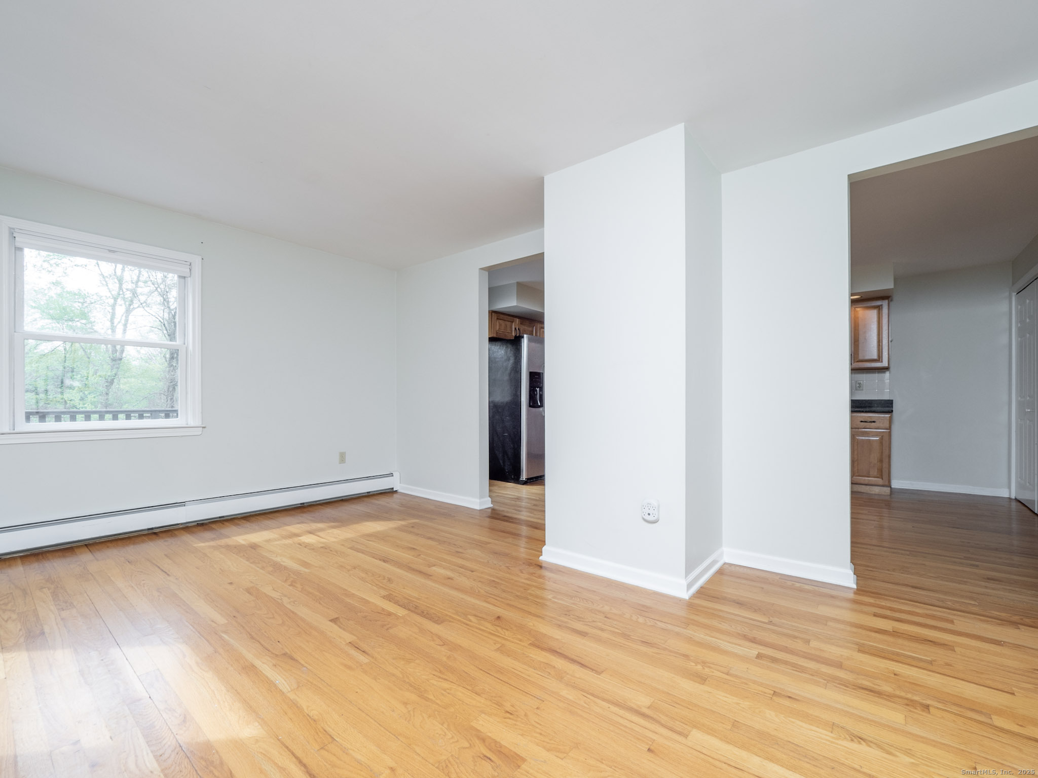 21 Simpaug Turnpike Redding, CT 06896 - Photo 4 of 22 a view of an empty room with wooden floor and a window