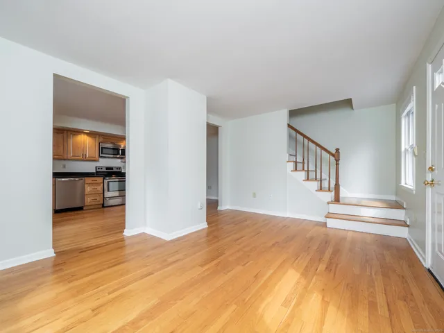 a view of a livingroom with wooden floor and a kitchen space