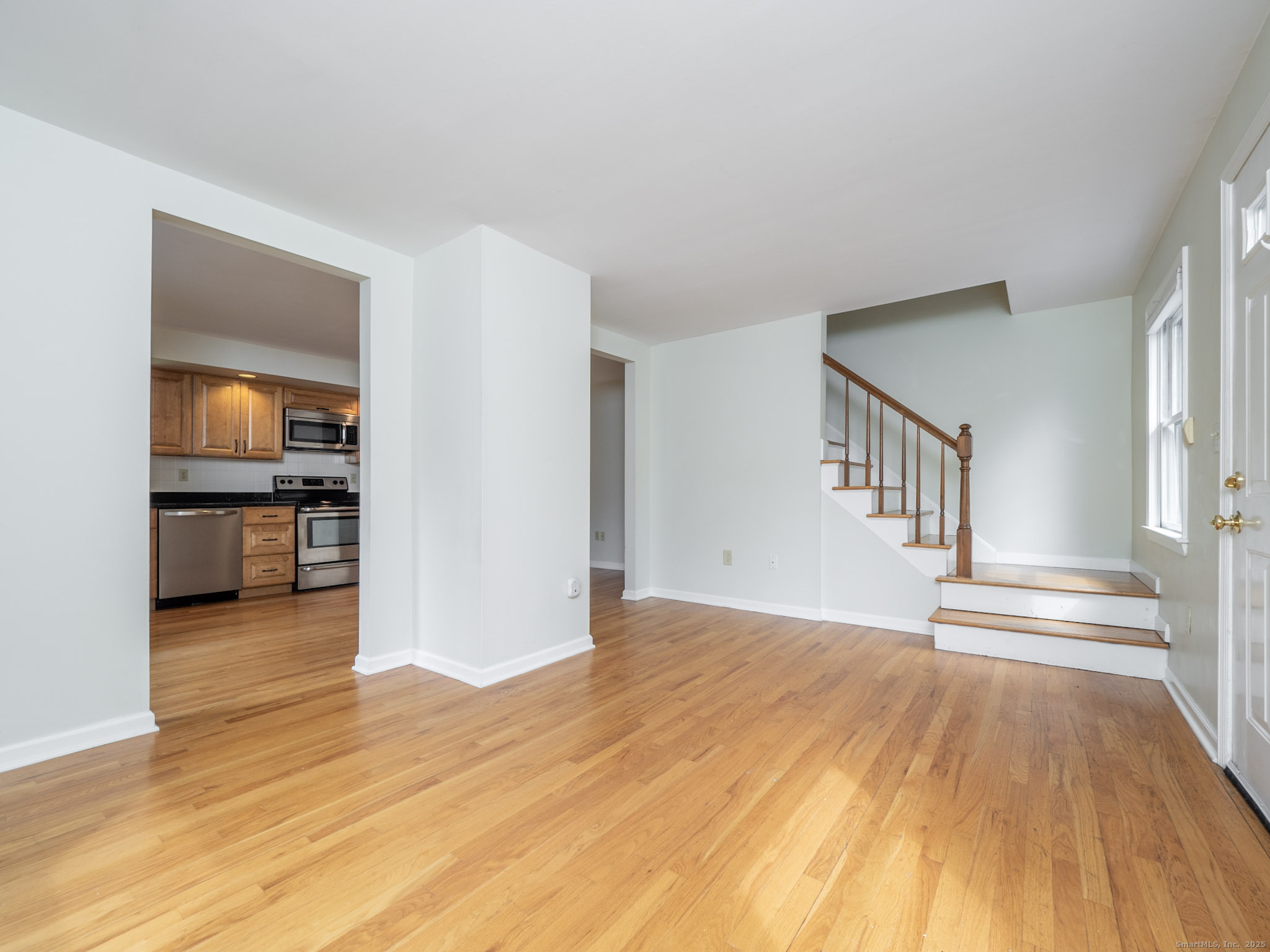 21 Simpaug Turnpike Redding, CT 06896 - Photo 5 of 22 a view of a livingroom with wooden floor and a kitchen space