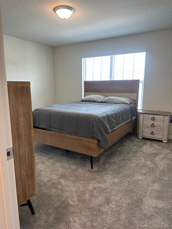 4669 Sparkling Shell Avenue Kissimmee, FL 34746 - Photo 14 of 21 a bedroom with a bed and a dresser