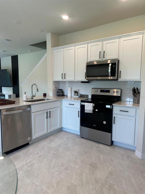 4669 Sparkling Shell Avenue Kissimmee, FL 34746 - Photo 3 of 21 a kitchen with a sink stove and cabinets